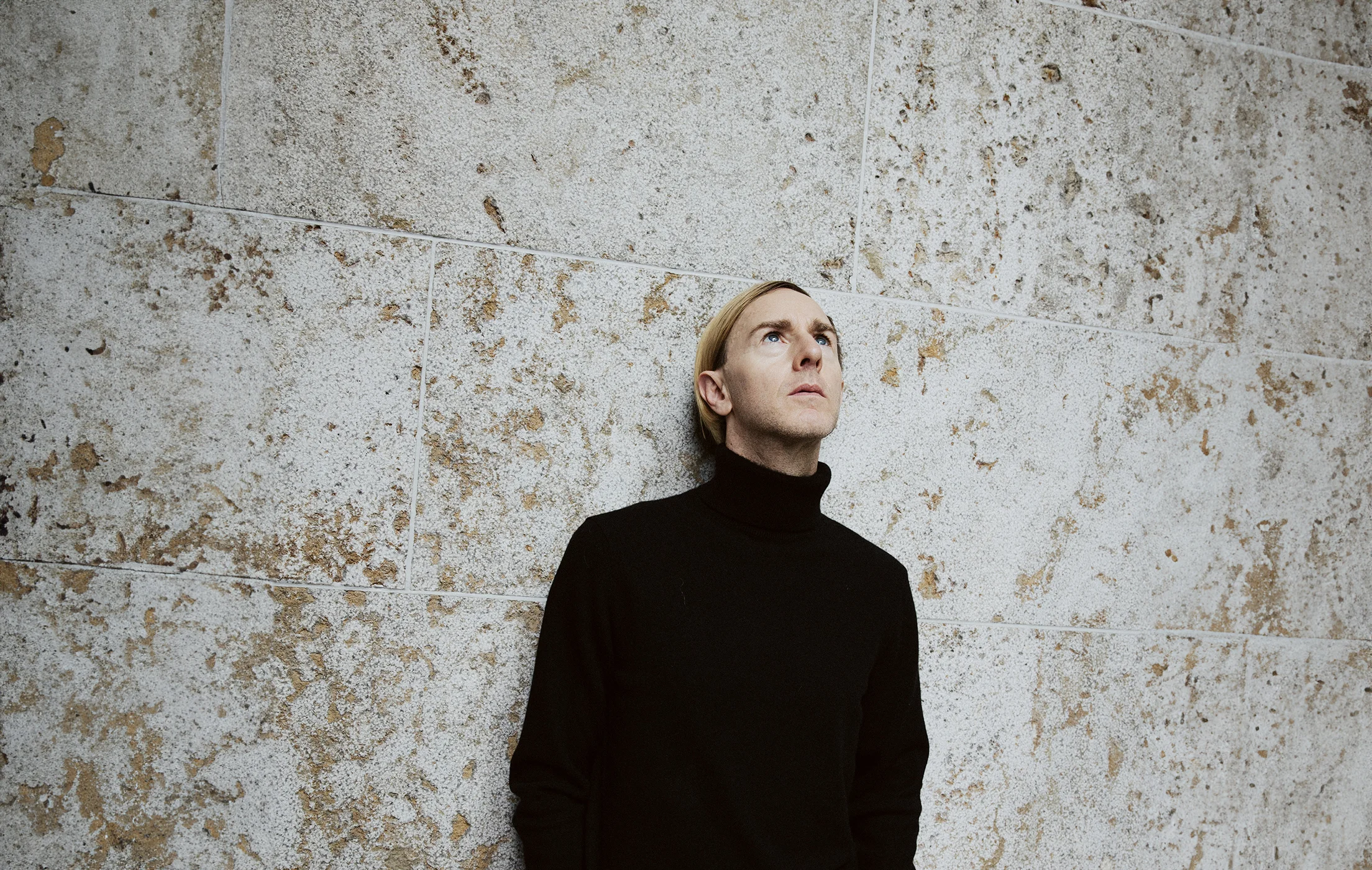 Il pioniere della musica elettronica Richie Hawtin appoggiato a un muro